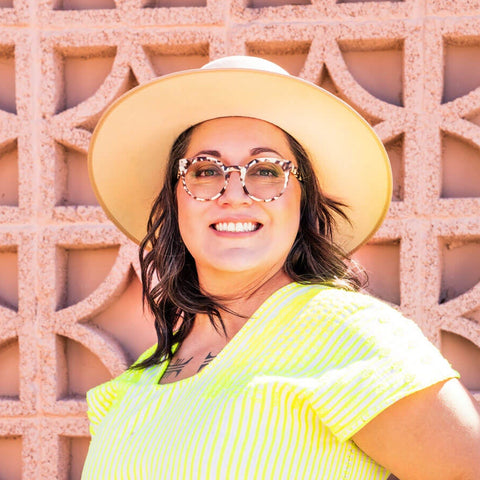 Temazcal Life founder Erika Aldrich Murga in front of a breeze block wall.