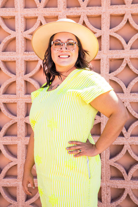 Temazcal Life founder Erika Aldrich Murga in front of a breeze block wall.